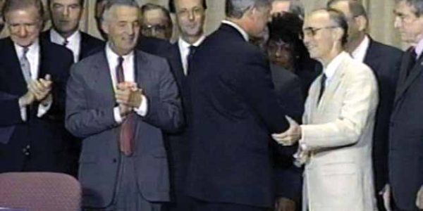 Former Fahe President, Dave Lollis, shakes the hand of President Bill Clinton after introducing him at the signing of the legislation establishing the CDFI Fund.