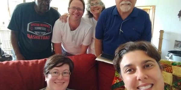 A group of people are smiling inside of a home.