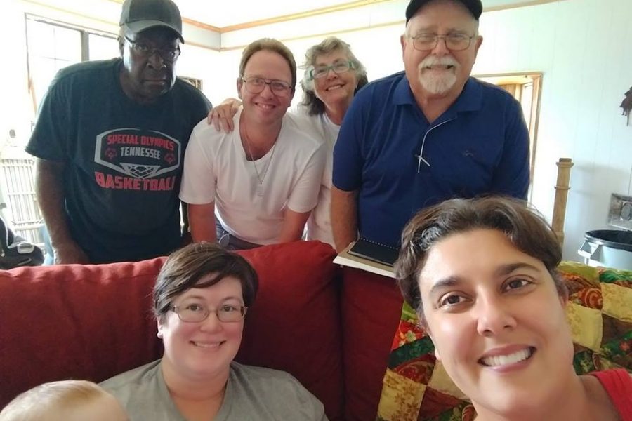 A group of people are smiling inside of a home.