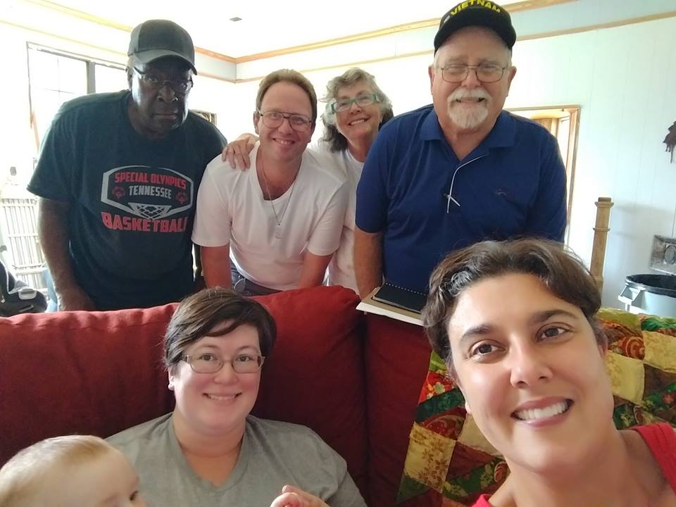 A group of people are smiling inside of a home.