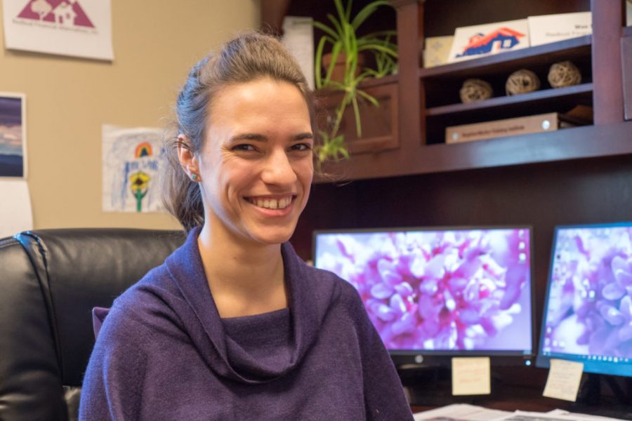 Mae Humiston, CDFI Manager, sitting at a desk with computer monitors behind her.