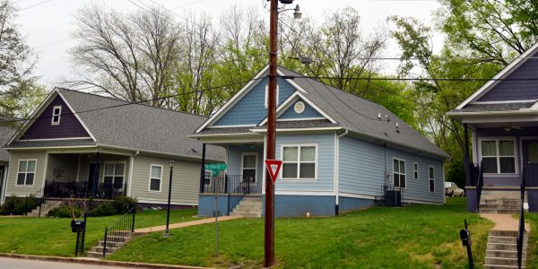 Five multi color one-story houses in a row.