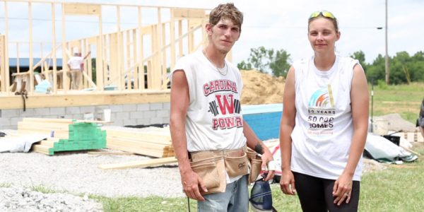Justin and Mandy McClellan standing outside of a home construction site.