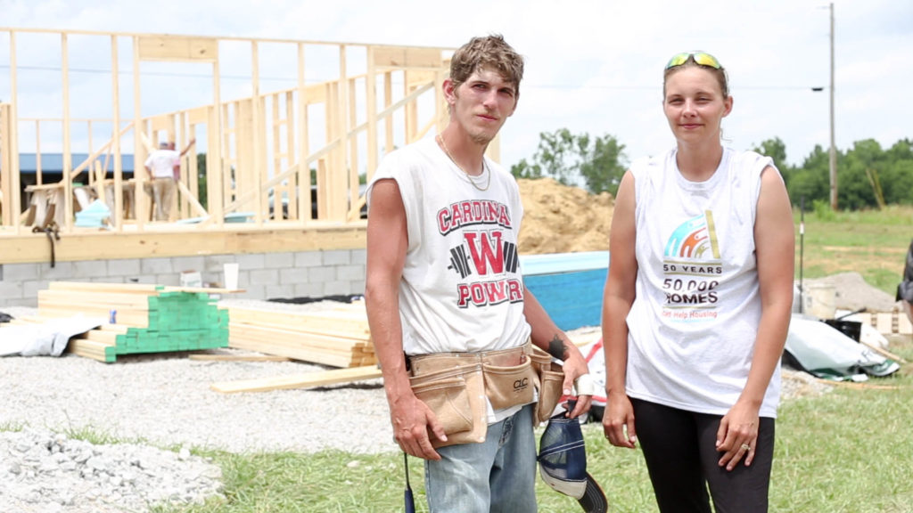 Justin and Mandy McClellan standing outside of a home construction site.